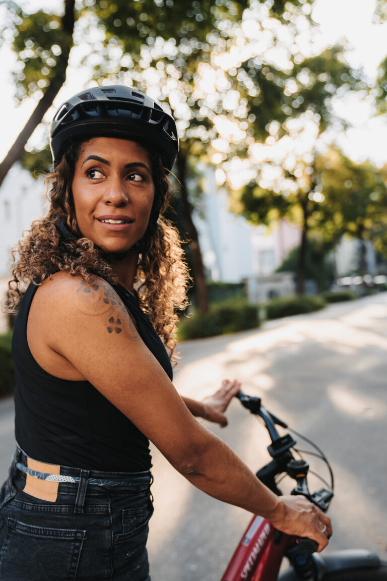 A Brazilian woman sitting on a bike in a city on a beautiful summer day